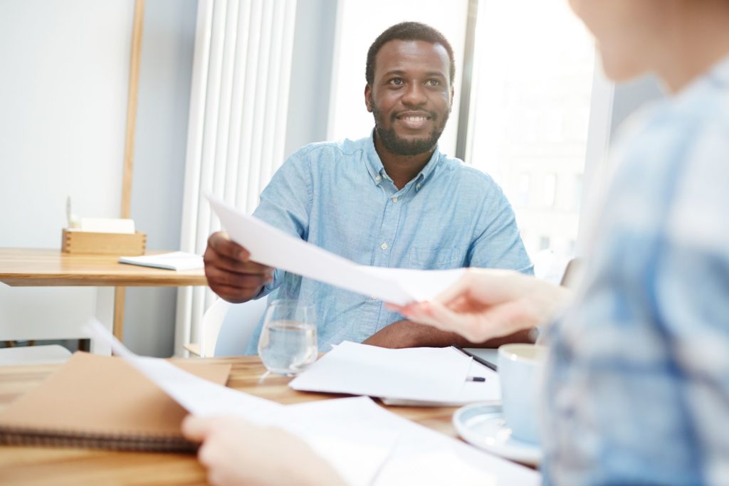 Businessman passing over paper or signed contract to his colleague or secretary